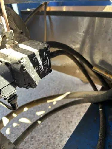 Old fuel line setup without filtration on Nilfisk DTE 500HM hot pressure washer before contaminated fuel repair in Leicester.